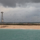 Birds fly around the Bramble Cay lighthouse tower. Rising waters have reduced vegetation dramatically in the past 10 years (Image: Ian Gynther)